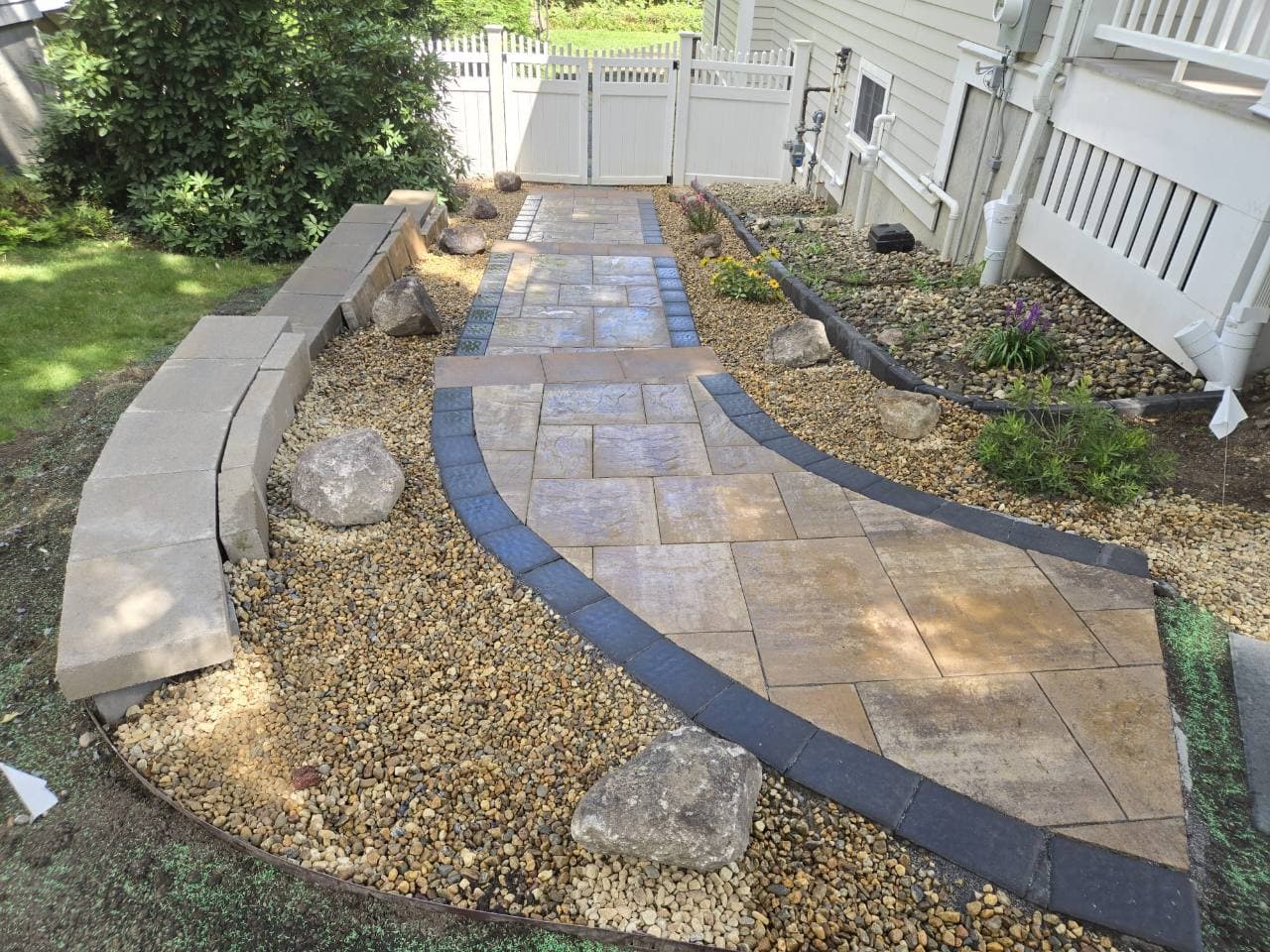 Curved walkway with a dark border, gravel and decorative rocks in Needham, MA